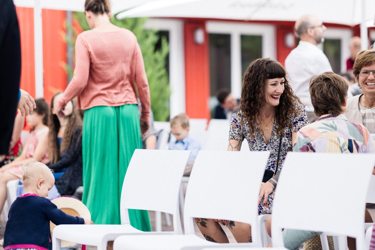 Gäste lachen und unterhalten sich vor der freien Trauung im Innenhof der OaseWeil