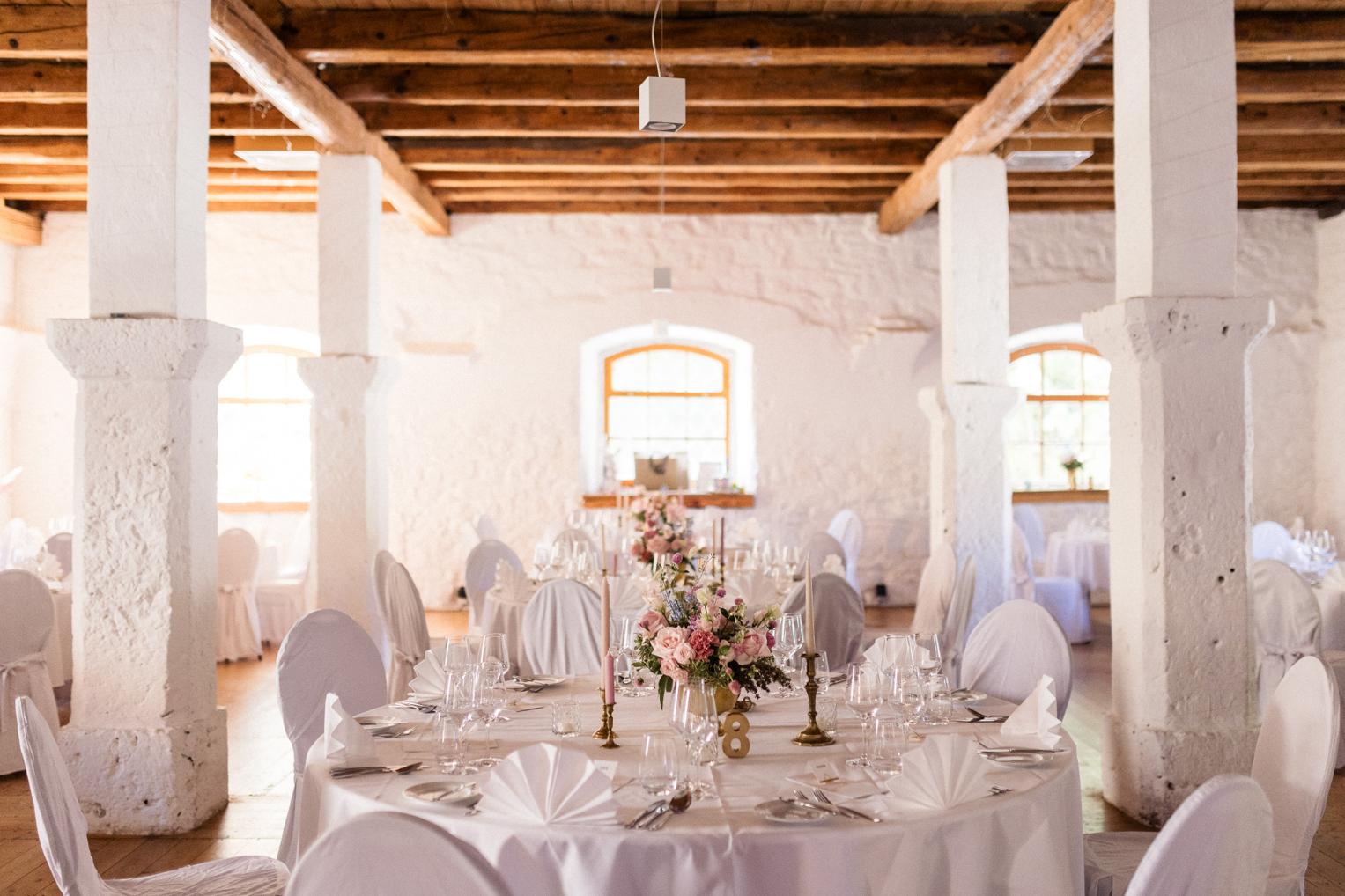 Festlich gedeckter Bankettsaal im Schloss Ehrenfels mit Blumendeko und Holzbalkendecke