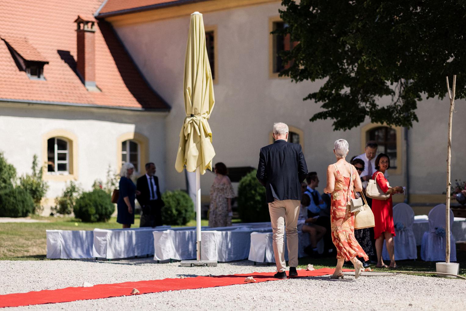 Gäste schreiten über den roten Teppich zum Zeremonieplatz im Innenhof Schloss Ehrenfels