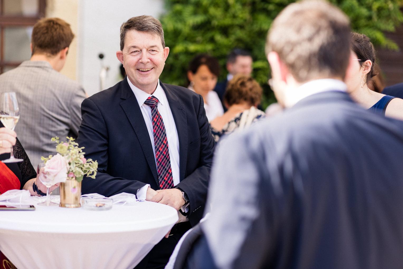 Gut gelaunter Gast beim Sektempfang im Innenhof von Schloss Ehrenfels