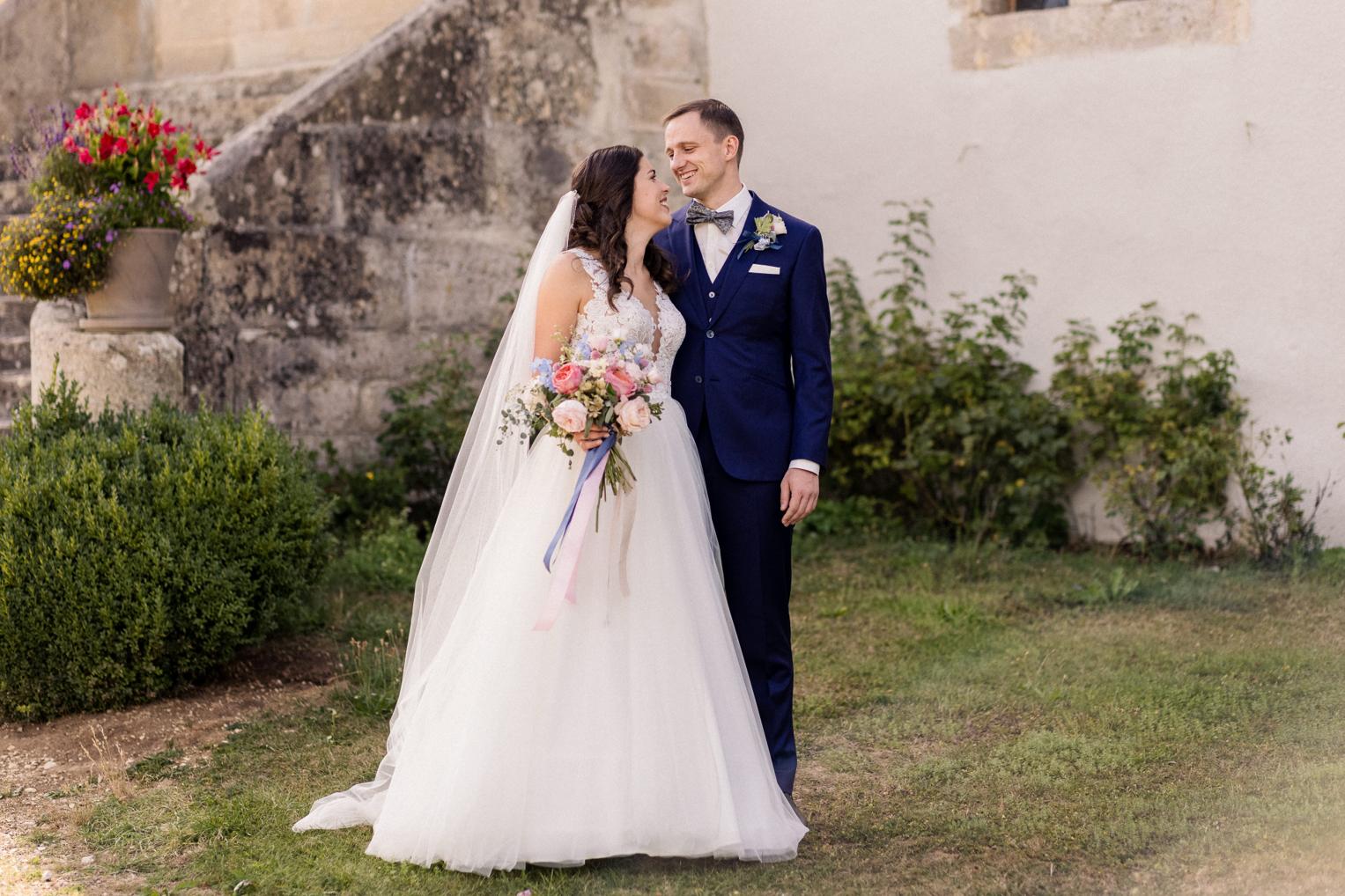 Brautpaar Portrait im sommerlichen Garten von Schloss Ehrenfels mit Blumen
