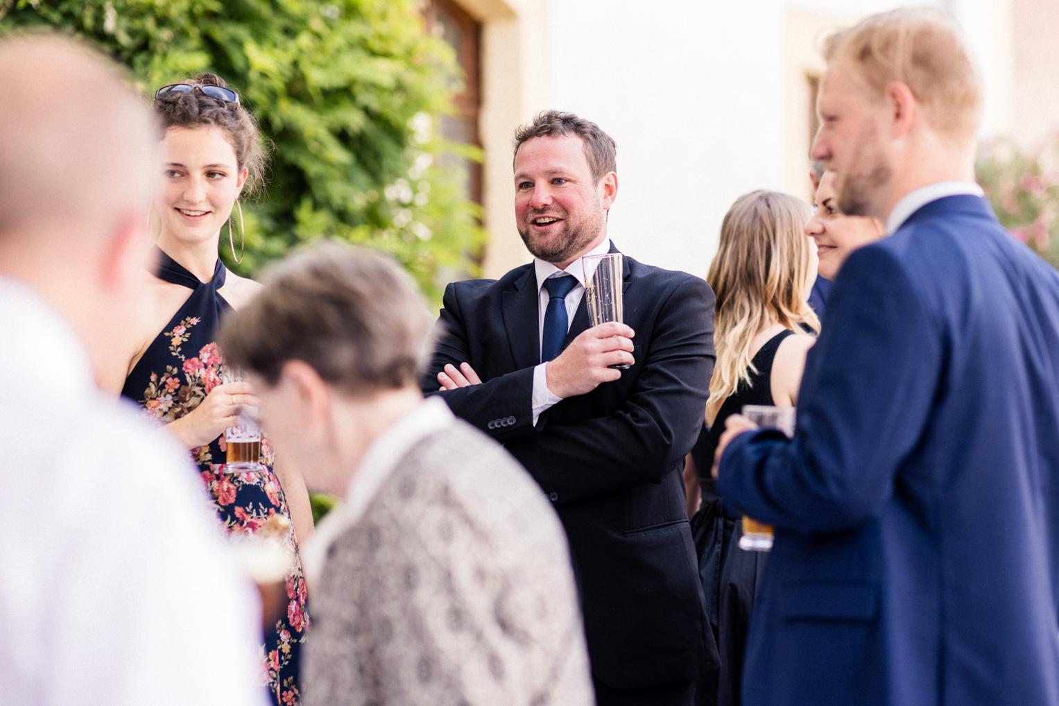 Gäste unterhalten sich entspannt beim Sektempfang im Innenhof Schloss Ehrenfels