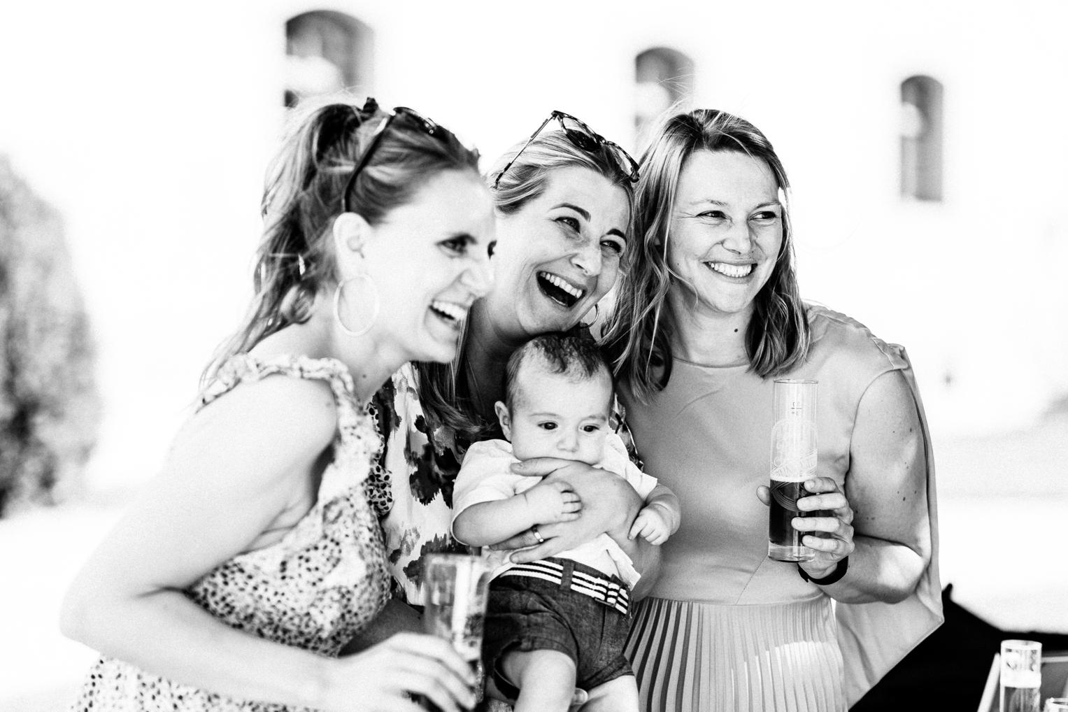 Drei Frauen mit Baby lachen ausgelassen beim Empfang Schloss Ehrenfels