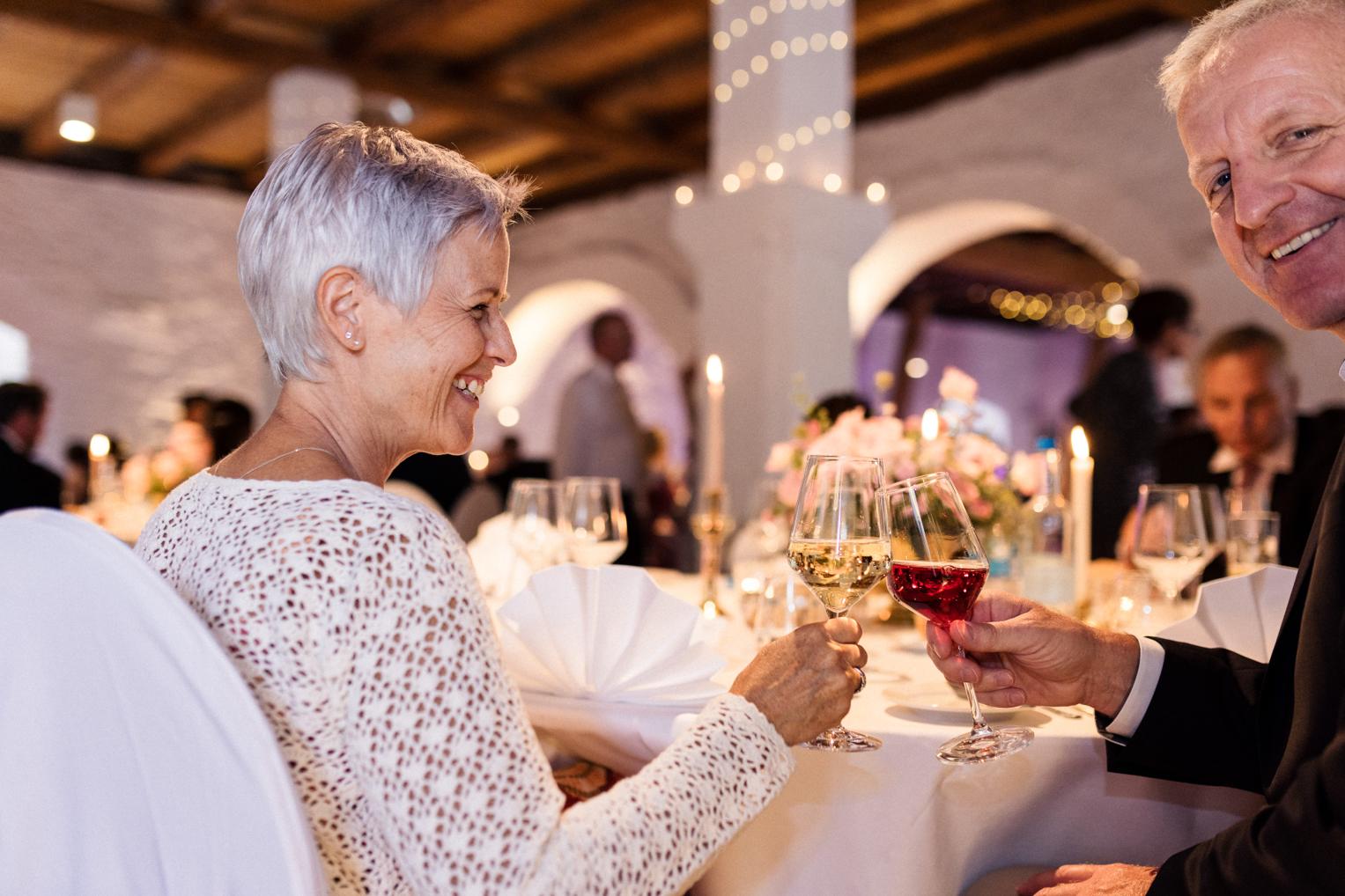 Gäste stoßen beim Hochzeitsdinner im Bankettsaal Schloss Ehrenfels mit Wein an
