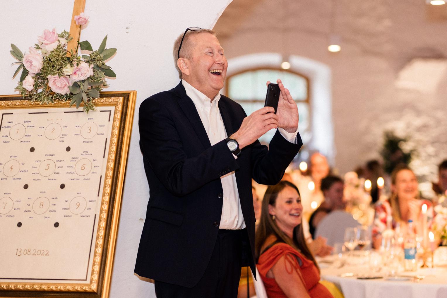 Gast lacht ausgelassen beim Hochzeitsfest im Innenhof Schloss Ehrenfels
