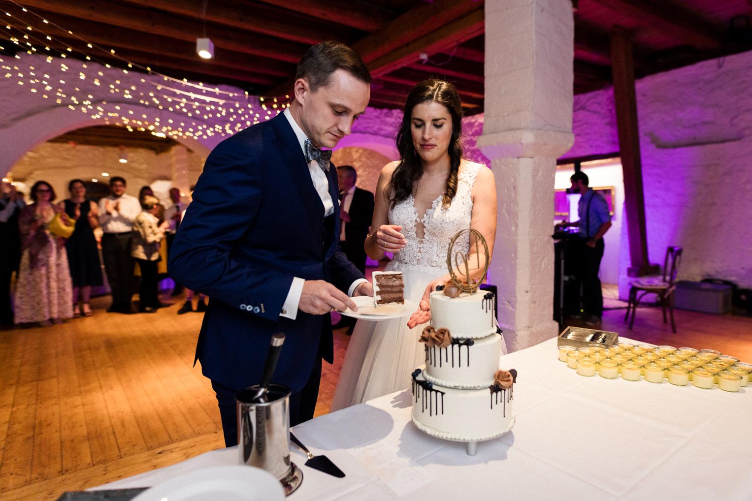 Brautpaar schneidet gemeinsam die Hochzeitstorte an, Schloss Ehrenfels