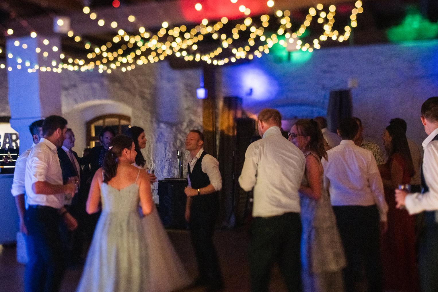 Gäste tanzen schwungvoll mit Lichtmalerei-Effekt beim Hochzeitsfest Schloss Ehrenfels