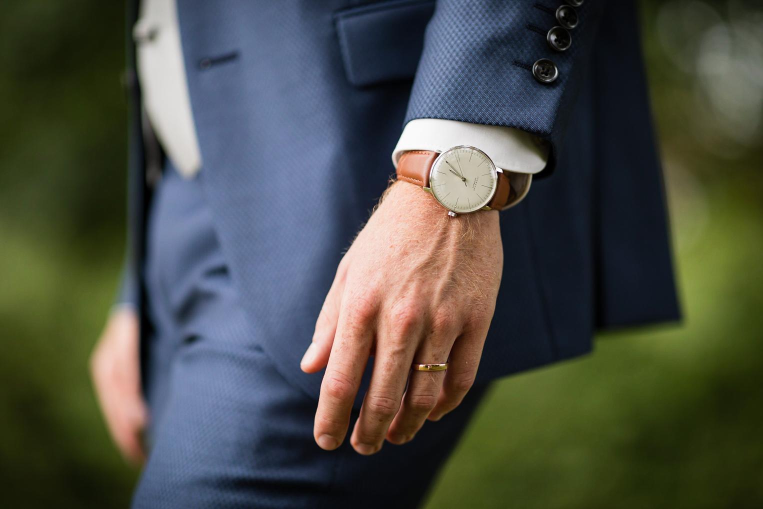 Hand des Bräutigams mit Uhr und frisch angestecktem Ehering