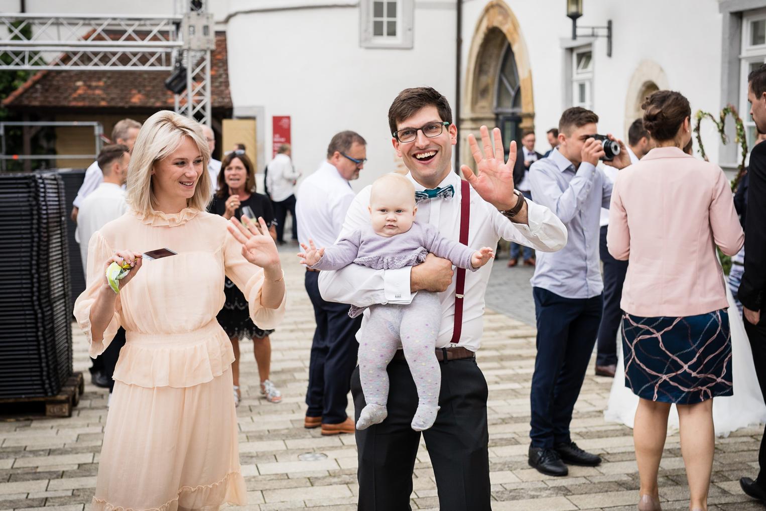 Gast hält sein Baby auf dem Innenhof von Schloss Filseck
