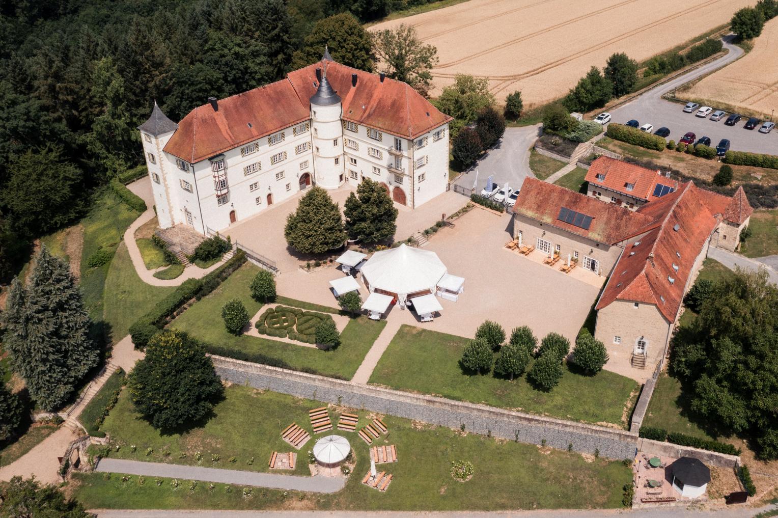 Luftaufnahme von Schloss Neuhaus bei Sinsheim – Schlossgebäude, Innenhof mit Pavillonzelt und Nebengebäude im Kraichgau