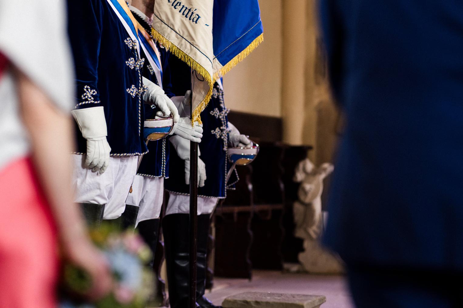 Chargierte mit Fahne und weißen Handschuhen stehen Spalier in der Kirche – Detail der Trauung auf Schloss Neuhaus