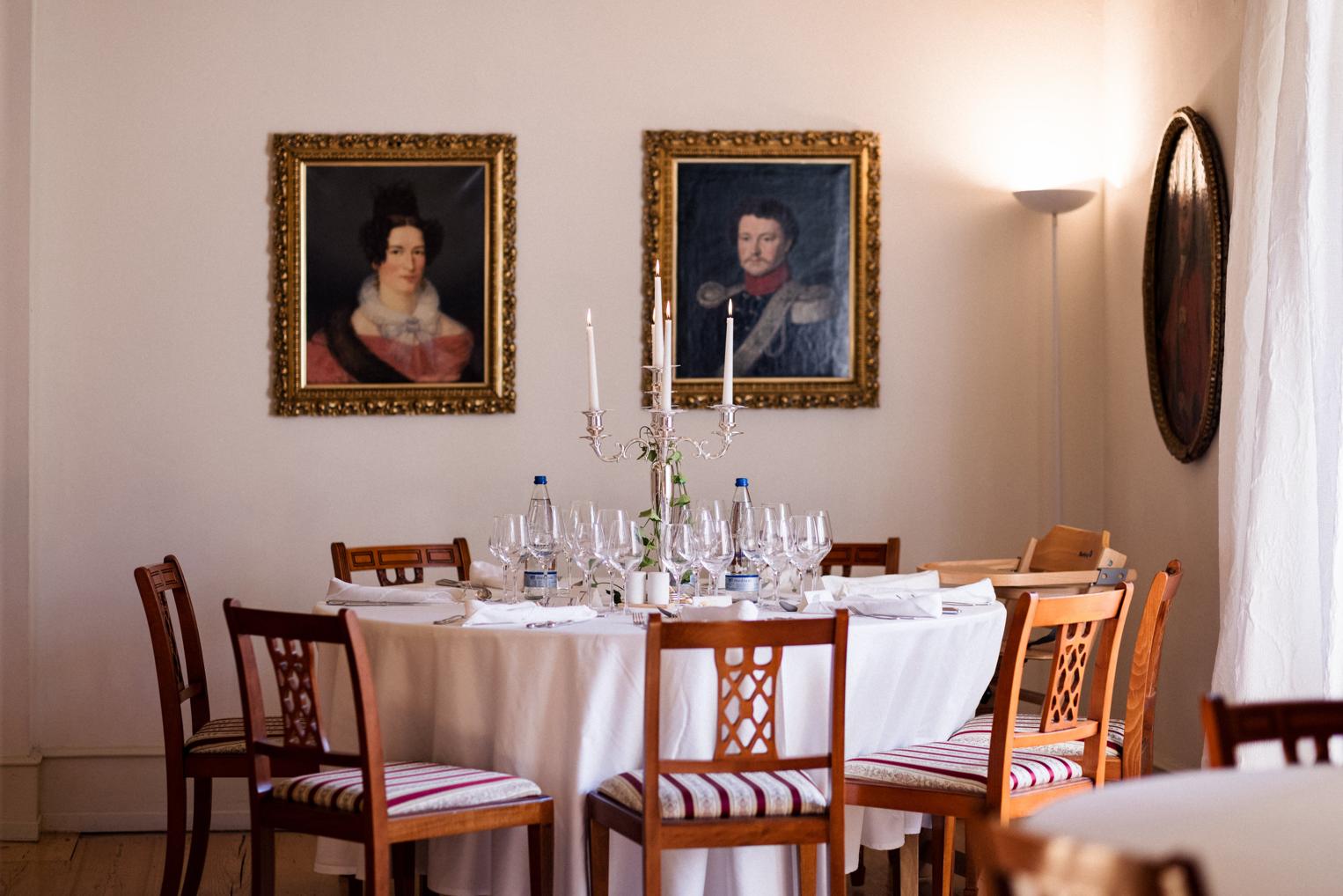Runder Hochzeitstisch unter historischen Ahnenporträts – Festsaal im Schloss bei Sinsheim