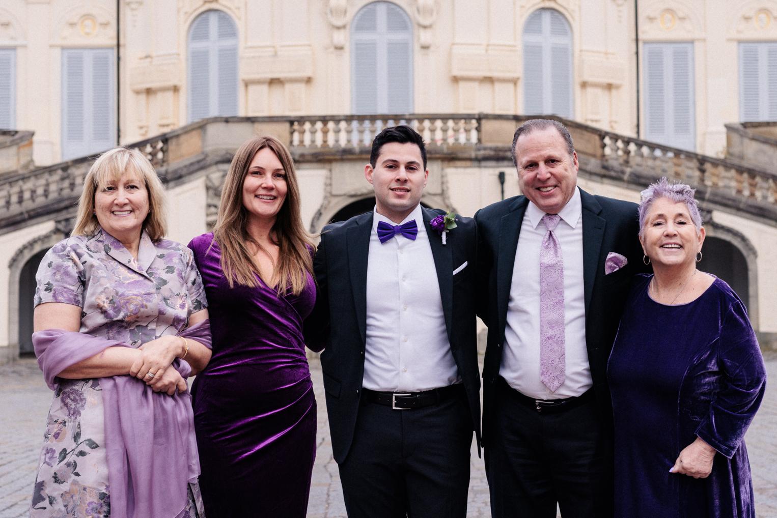 Familien-Gruppenfoto in Lila-Tönen vor der Freitreppe von Schloss Solitude, Bräutigam mit Eltern und Angehörigen