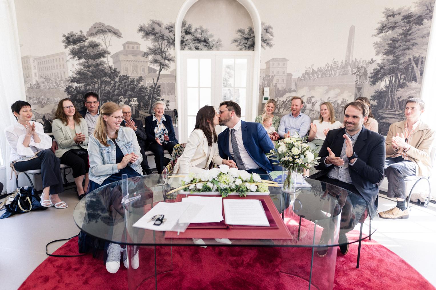Kuss des Brautpaares beim Standesamt in der Villa Schwalbenhof – Gäste applaudieren begeistert