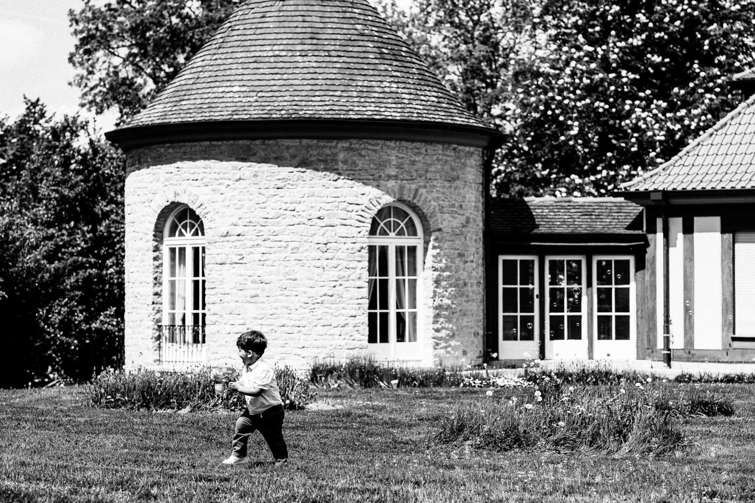 S/W – Kind läuft fröhlich auf der Wiese vor dem Turmzimmer der Villa Schwalbenhof