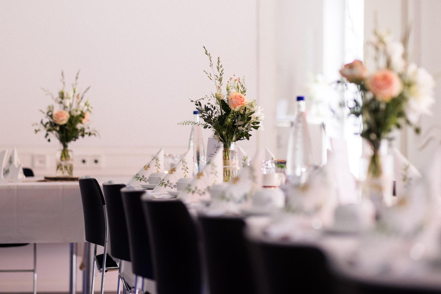 Tischdekoration im Erich-Kiefer-Saal der Villa Schwalbenhof – rosafarbene Rosen, weiß gedeckte Tafel