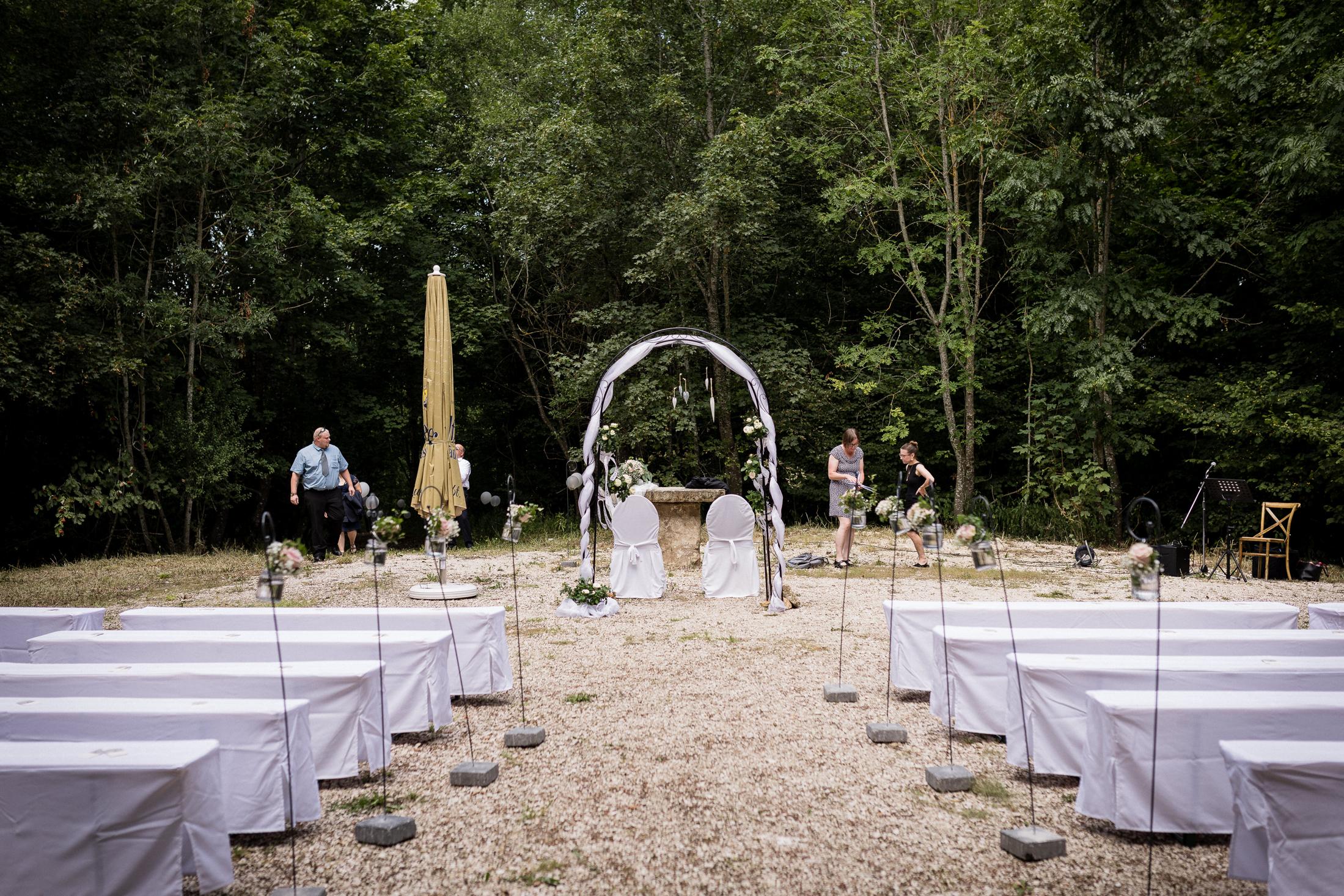 Trauungssetup mit Metallbogen und Blumendeko am Platz im Grünen auf dem Albgut