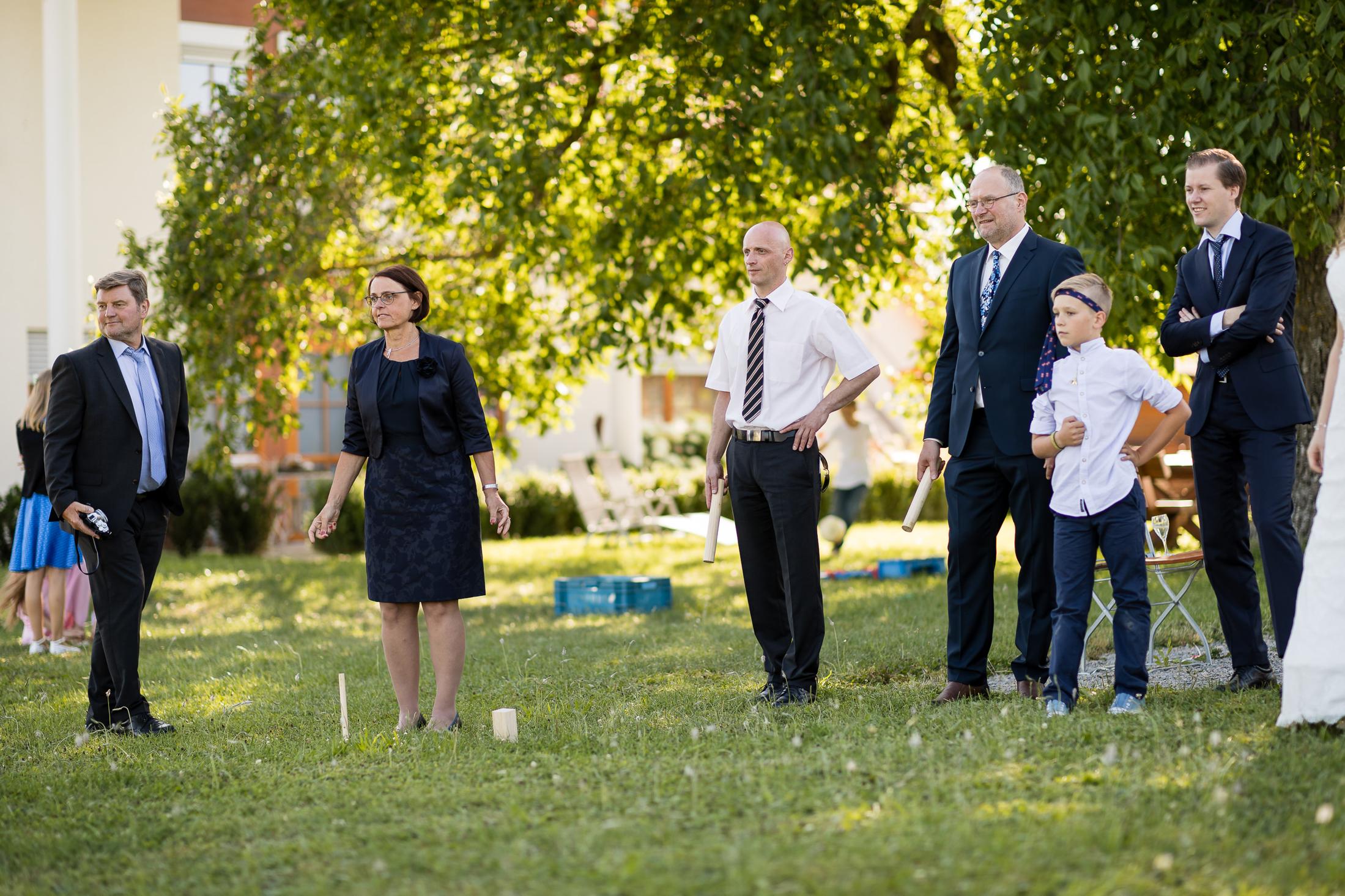Hochzeitsgesellschaft spielt Wikingerschach auf dem Rasen