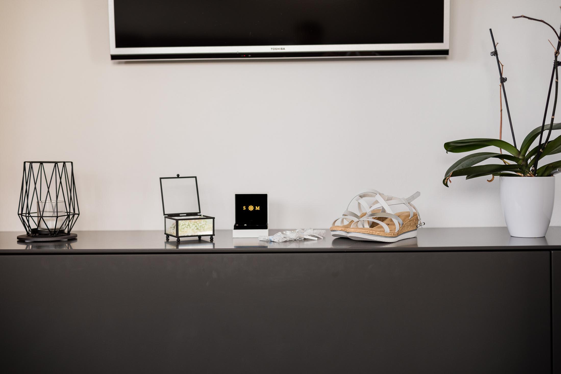 Hochzeitsdetails auf der Anrichte: Ringbox, Brautschuhe und Schmuckkästchen