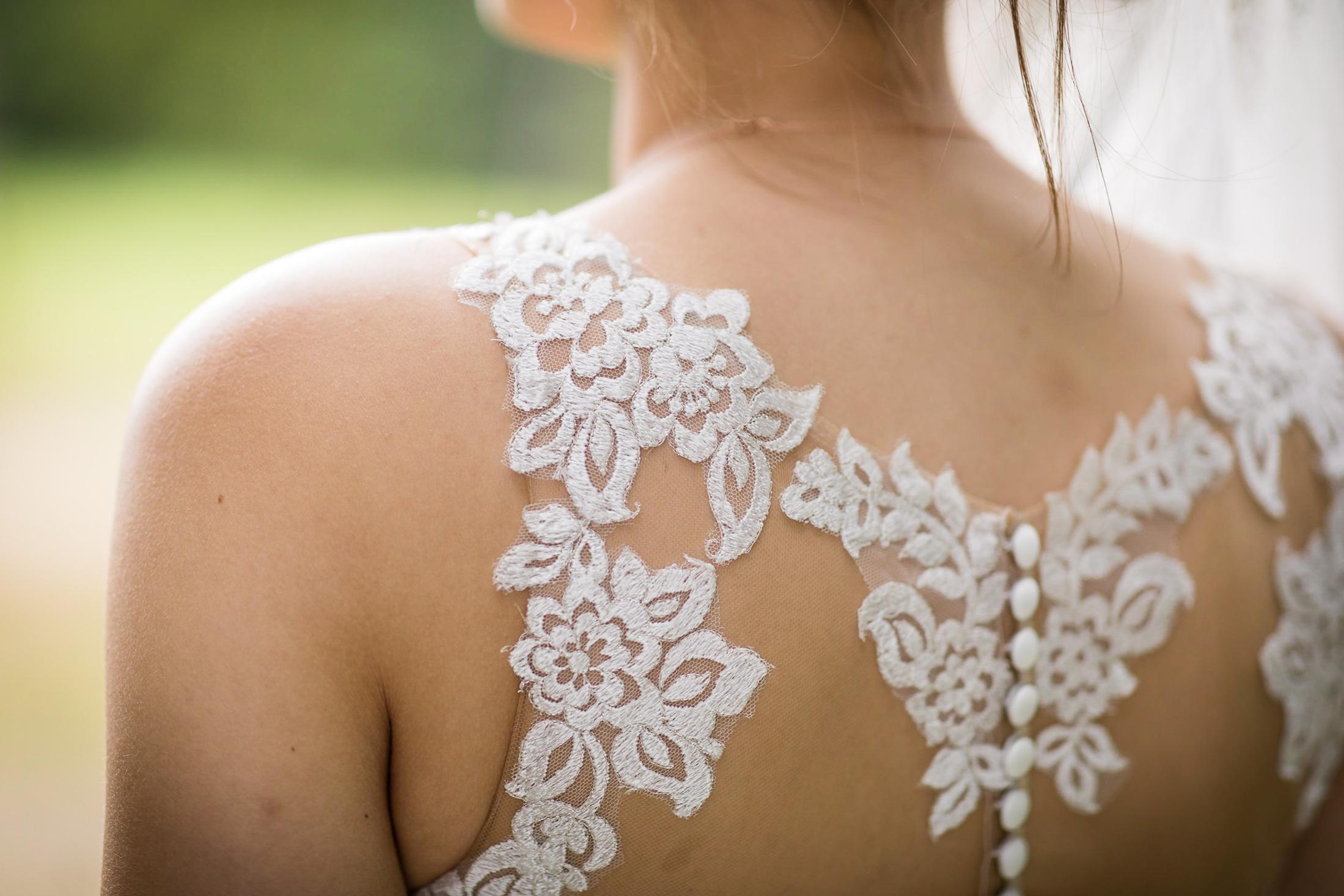 Detail vom Spitzenrücken des Brautkleids mit Knopfleiste