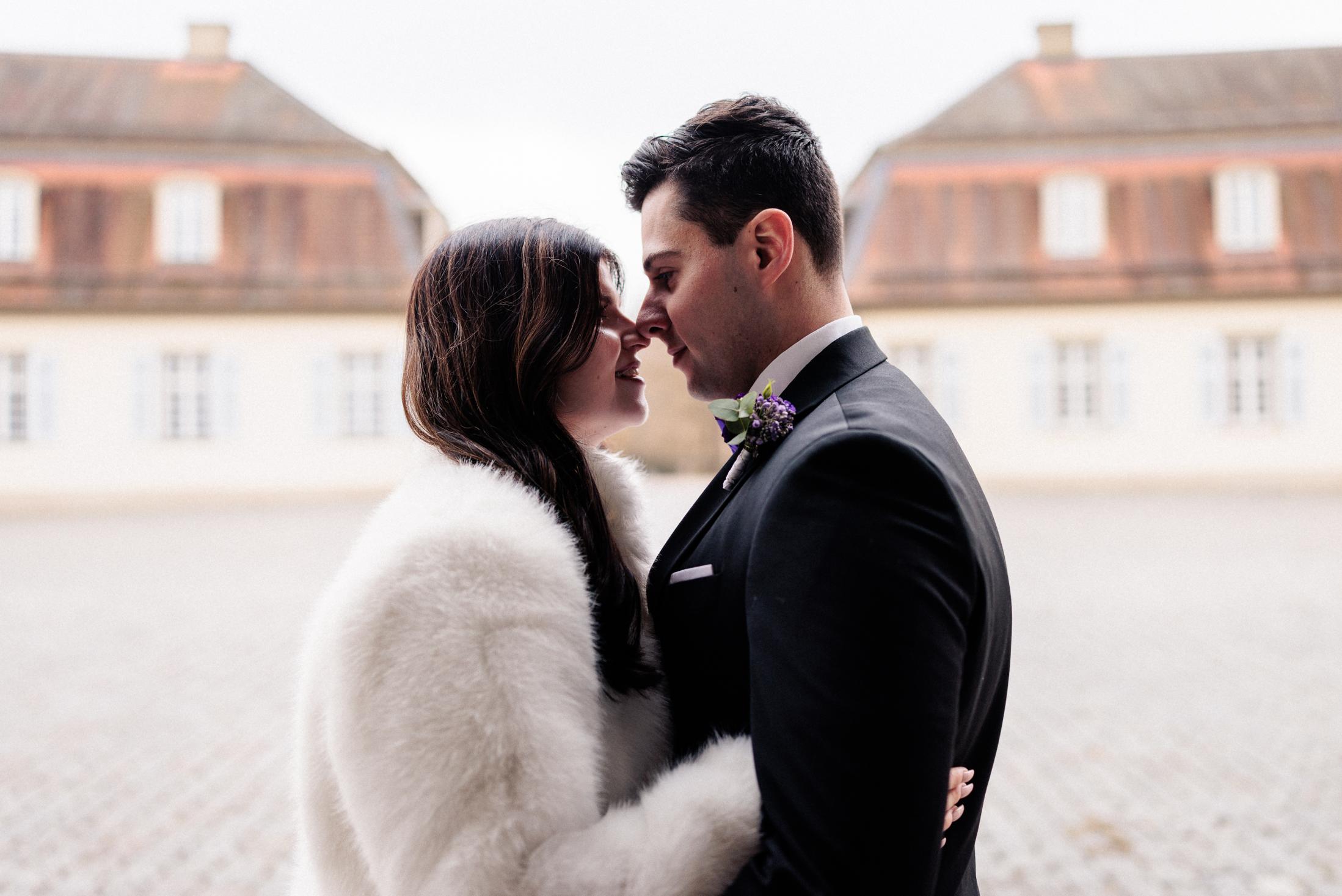 Brautpaar Nase an Nase in romantischem Moment vor den historischen Gebäuden von Schloss Solitude