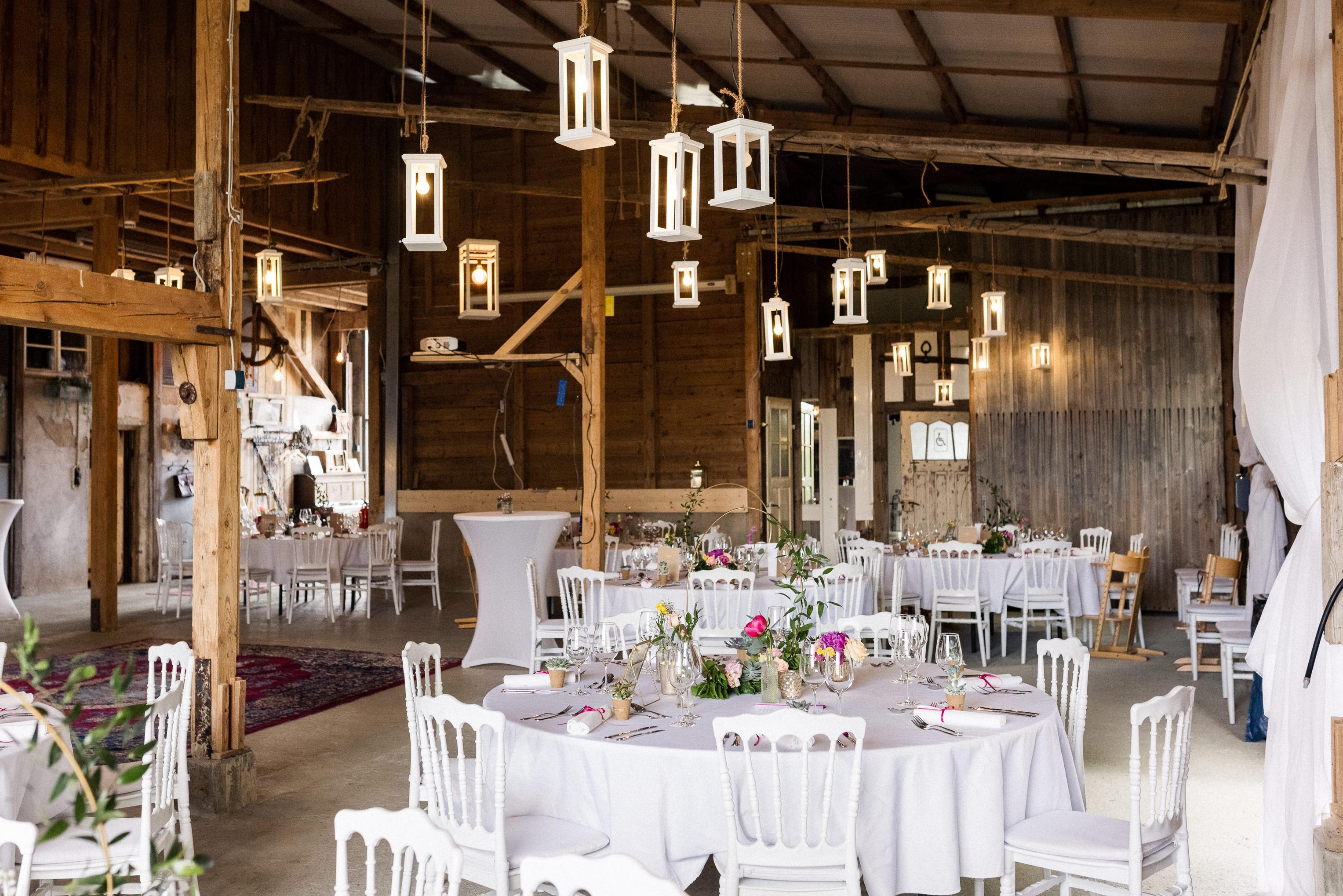 Festlich gedeckte Hochzeitstafel in der Scheune des Lindenhof Mötzingen mit hängenden Laternen
