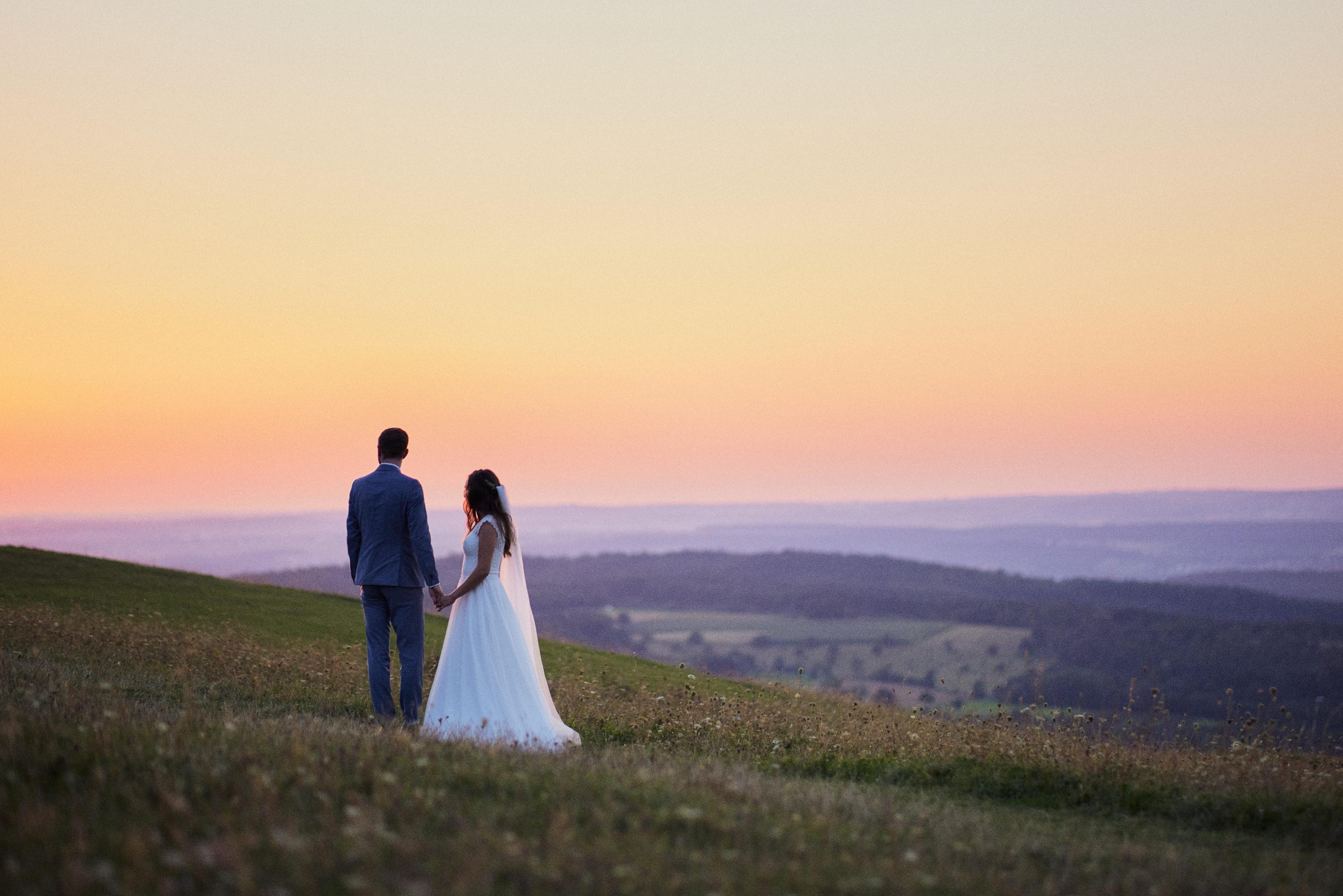 Brautpaar Hand in Hand vor Sonnenuntergang auf dem Hohenbol