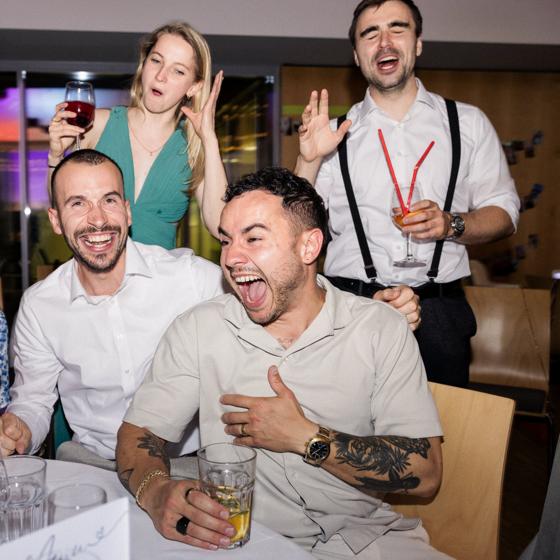 Ausgelassene Hochzeitsgäste lachen und feiern gemeinsam bei der Party am Abend